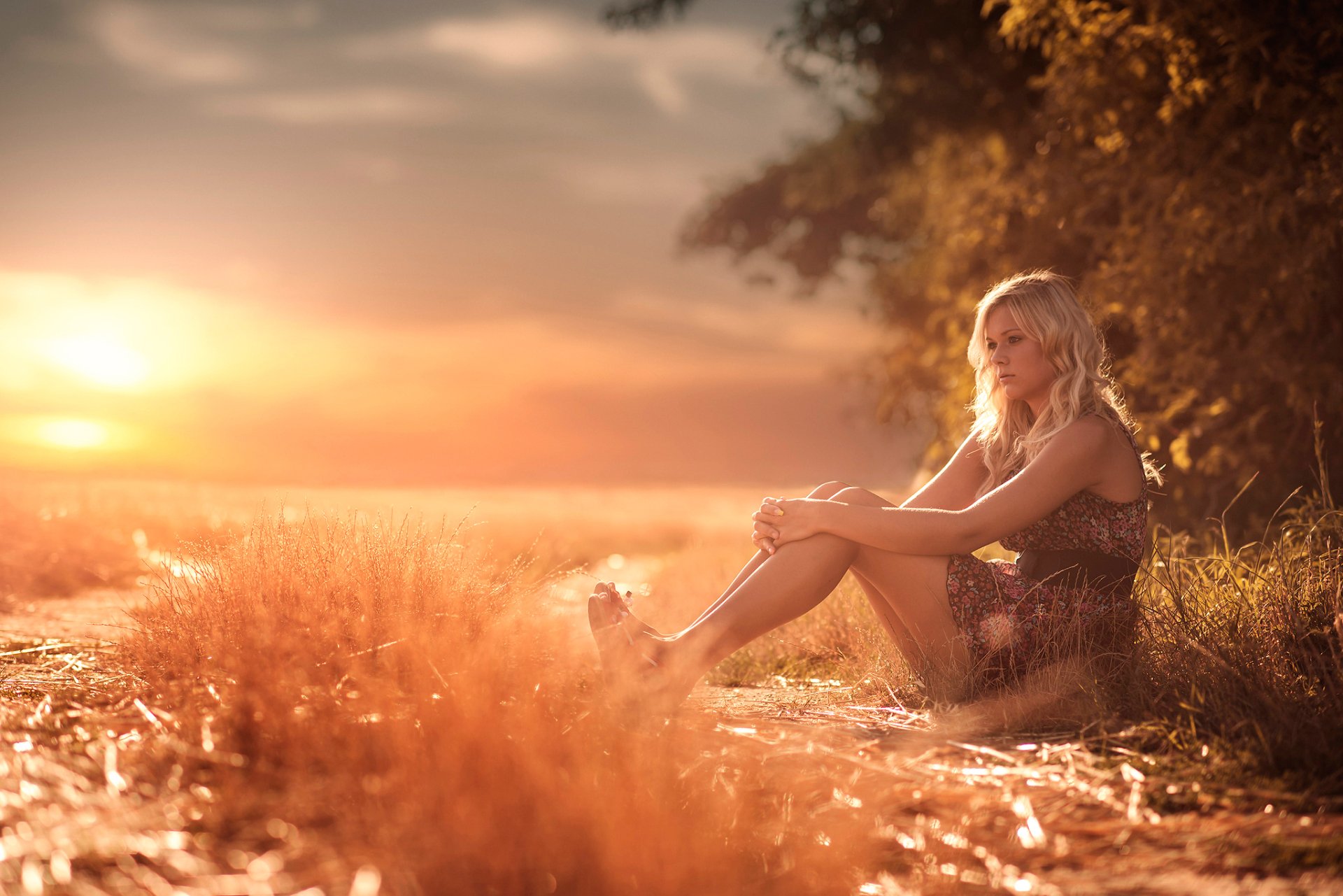 Очаровательная блондинка голая сидит на траве