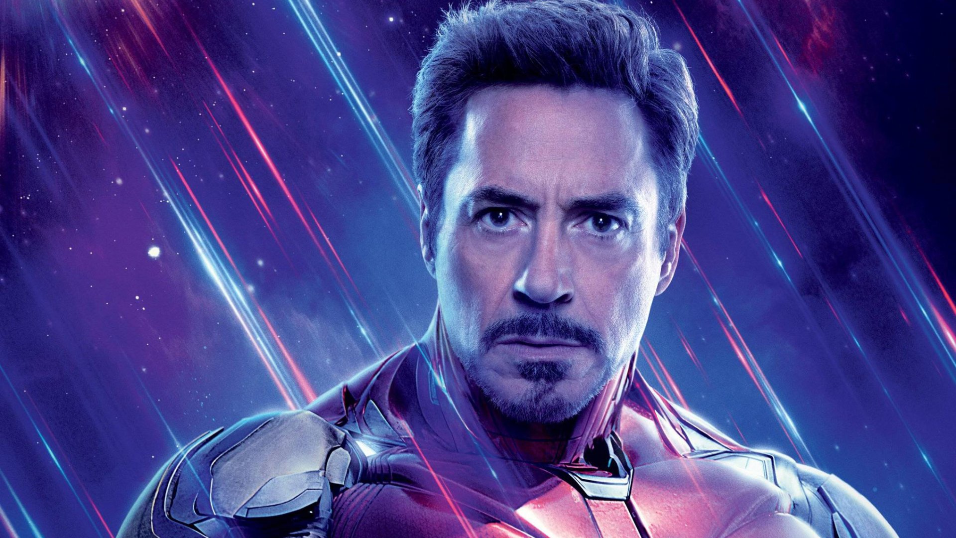 HD desktop wallpaper of Robert Downey Jr. as Iron Man from Avengers Endgame, featuring vibrant cosmic background with streaks of light.