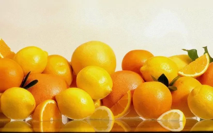 HD desktop wallpaper featuring a vibrant assortment of fresh oranges and lemons against a neutral background, highlighting the natural colors and textures of the fruits.