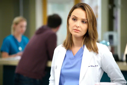 HD desktop wallpaper featuring a character from Grey's Anatomy, in a white lab coat, against a hospital backdrop.