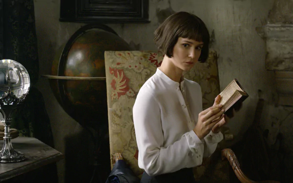 HD wallpaper featuring a pensive individual with a short haircut, clad in a white shirt, holding a book in a vintage-styled room with antique decor.