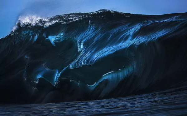 HD desktop wallpaper featuring a powerful, dark wave crashing in a dramatic nature scene. The wave's motion and details are captured with stunning clarity, making for a captivating background.
