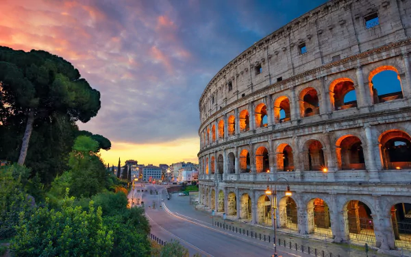 HD PC desktop wallpaper featuring the Colosseum in Rome at sunset, showcasing the ancient man-made structure with warm interior lighting and a colorful sky.