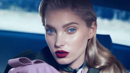 Close-up portrait of Swedish model and celebrity Elsa Hosk with blonde hair, striking blue eyes, and bold lipstick, captured in 4K Ultra HD.