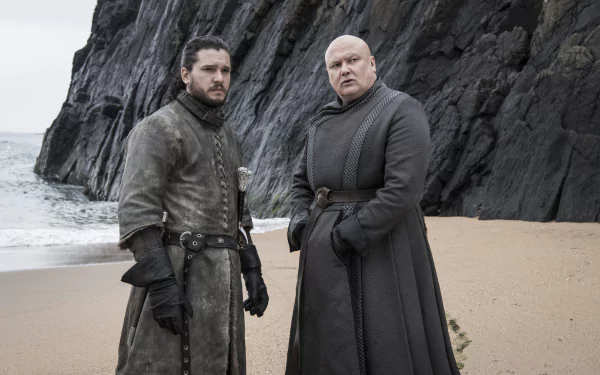 Game of Thrones 2K Quad HD desktop wallpaper: a brooding swordsman and a bald advisor in dark cloaks stand on a windswept rocky beach.