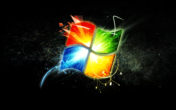 HD PC desktop wallpaper showing a glowing, stylized Windows 7 logo with blue, red, green, yellow light bursts on a dark, textured technology background.