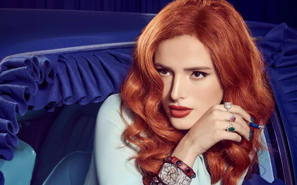 5K Ultra HD wallpaper: glamorous redhead with brown eyes and red lipstick, wearing rings and a wristwatch, posed in a car.