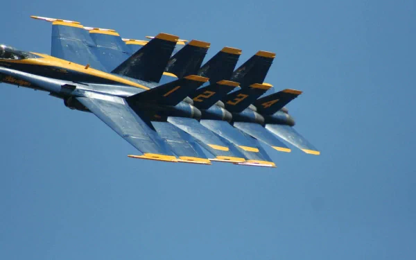 HD desktop wallpaper showing a close-up of military aircraft jet fighters flying in tight formation against a clear blue sky.