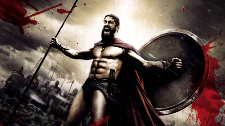 HD desktop wallpaper featuring Gerard Butler as King Leonidas from the movie 300, in battle stance with a spear and shield, set against a dramatic sky and blood splatters.