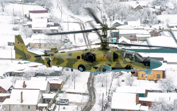 HD desktop wallpaper featuring a military Kamov Ka-52 attack helicopter flying over a snowy village landscape.