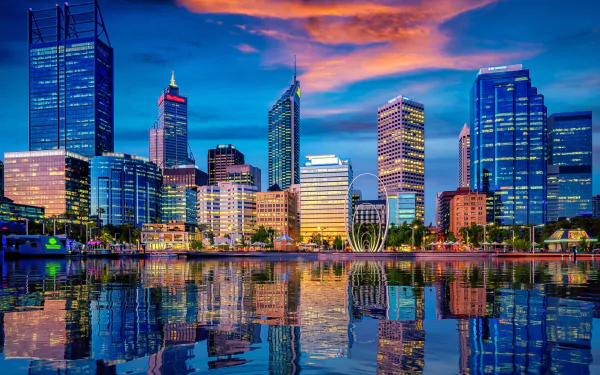 HD desktop wallpaper showcasing the vibrant Perth city skyline in Western Australia, with skyscrapers reflecting beautifully on the calm water at sunset.