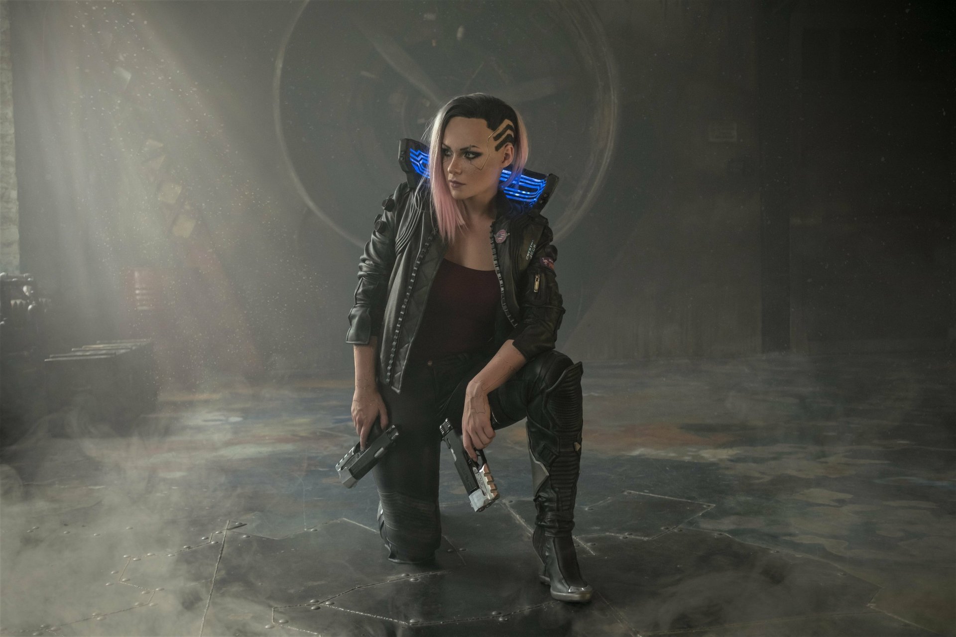 4K Ultra HD Cyberpunk 2077 wallpaper featuring a woman warrior with pink hair crouching in a dark, futuristic setting, holding two pistols.