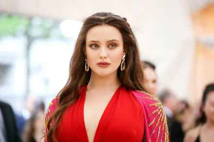 HD desktop wallpaper of Australian actress Katherine Langford with long brunette hair, blue eyes, bold lipstick, and earrings, captured with a shallow depth of field.