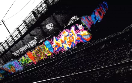 A vibrant, artistic graffiti mural on a black and white urban railway background, presented as an HD desktop wallpaper.