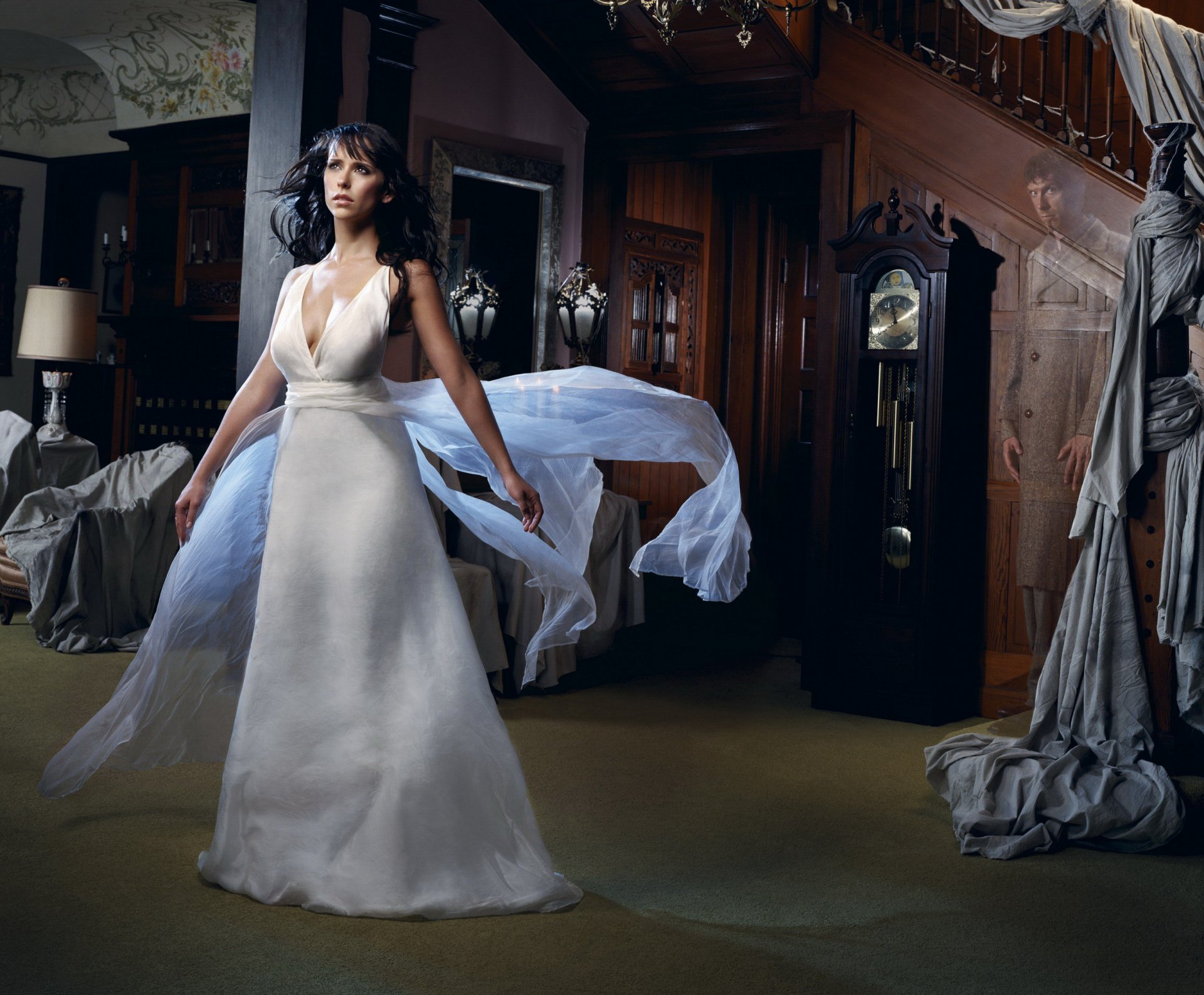 HD desktop wallpaper featuring Jennifer Love Hewitt in a flowing white dress, standing in a dimly lit, antique room with elegant, vintage furnishings.