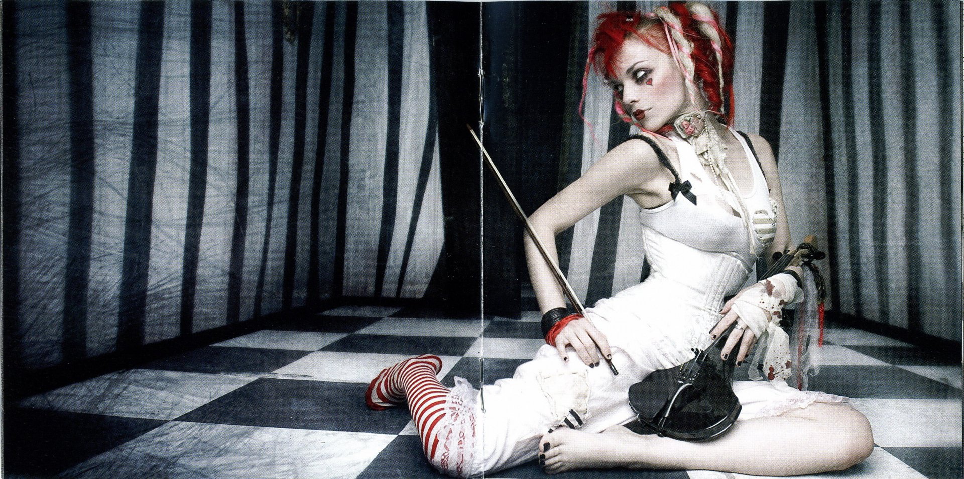 Gothic singer with red hair and striped stockings seated on a black-and-white checkered floor, holding a violin amid dark curtains — HD PC desktop wallpaper