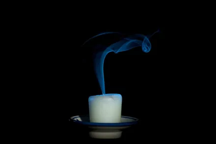 Artistic HD PC desktop wallpaper of a white candle with a swirling blue flame against a black background.