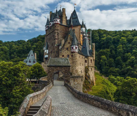 HD wallpaper of Eltz Castle, a stunning man-made medieval fortress nestled in lush greenery in Germany.