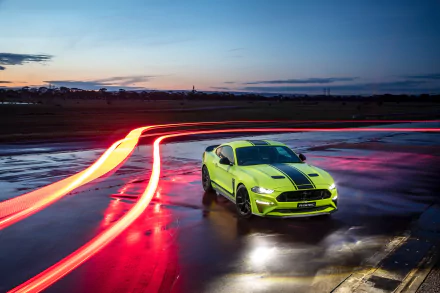 A green Ford Mustang R-Spec muscle car parked on wet pavement at dusk with time-lapse light trails, captured in 4K Ultra HD for a dynamic desktop wallpaper.