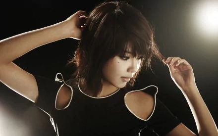 A stylish Asian female pop artist from Girls' Generation (SNSD) poses confidently in a dark setting, showcasing her trendy outfit and captivating presence. This HD image serves as a striking desktop wallpaper.