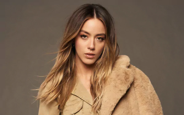 Portrait of American actress and celebrity Chloe Bennet in a tan fur coat, captured in a 4K Ultra HD PC desktop wallpaper and background.