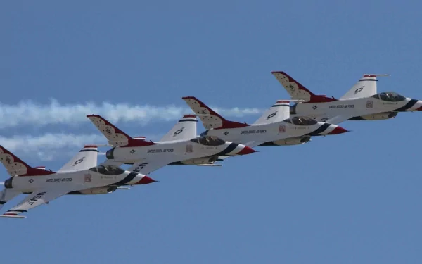 A stunning HD wallpaper featuring a formation of F-16 fighter jets performing a stunt, showcasing military precision against a clear blue sky.
