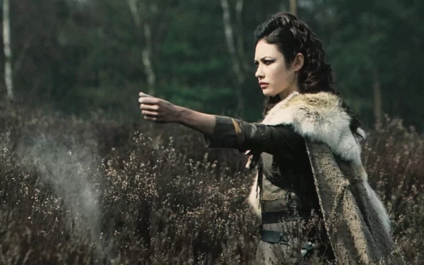 Brigantian warrior from the movie Centurion stands in a misty heath, dressed in fur and armor, captured in an HD PC desktop wallpaper and background.