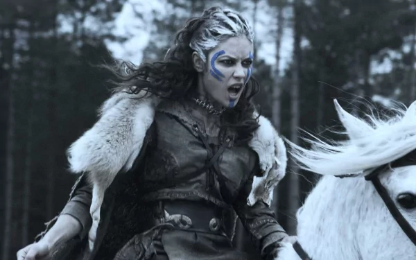 HD desktop wallpaper of a fierce Brigantian warrior from the movie Centurion, clad in battle gear and riding a white horse through a forest.