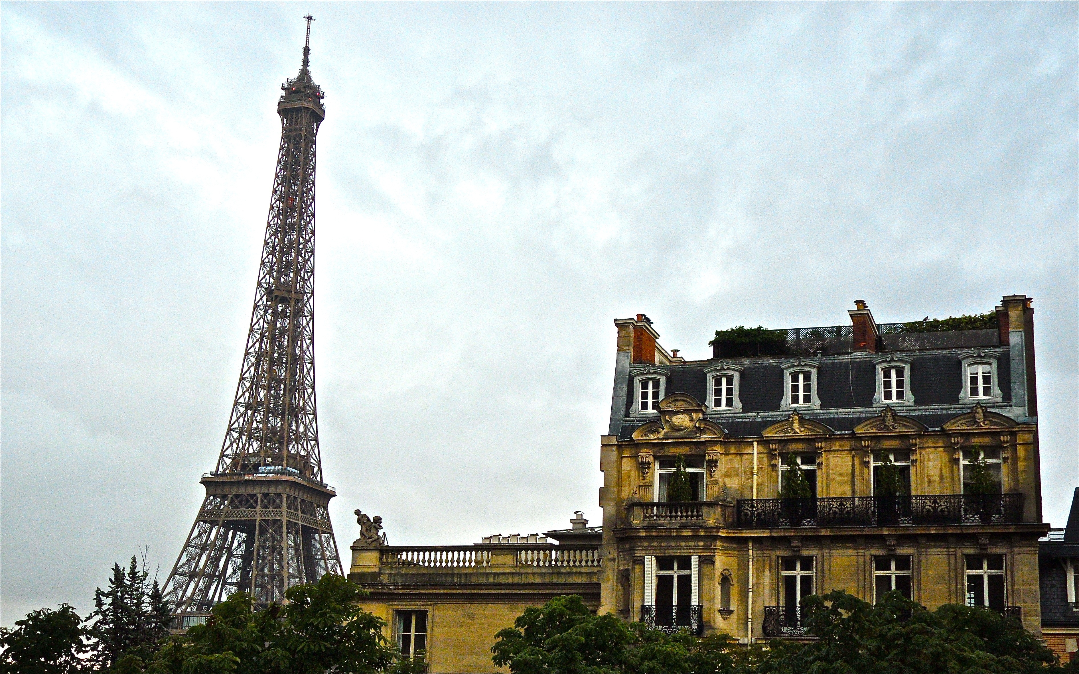 Summer Storm in Paris with the Eiffel Tower, a house, and man-made structures.