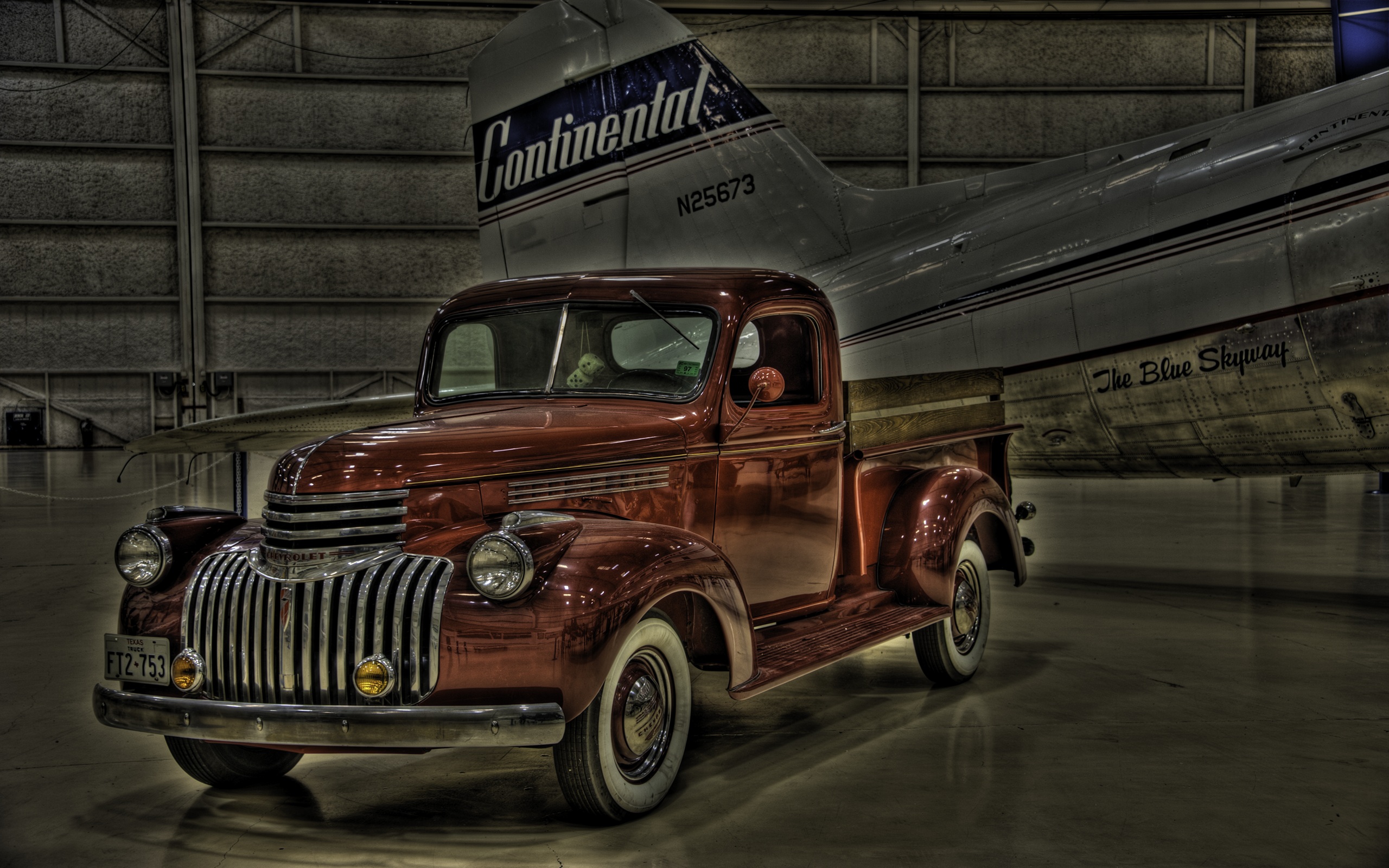 1941 Chevrolet Pickup Truck parked in a hangar with an aircraft in HDR.