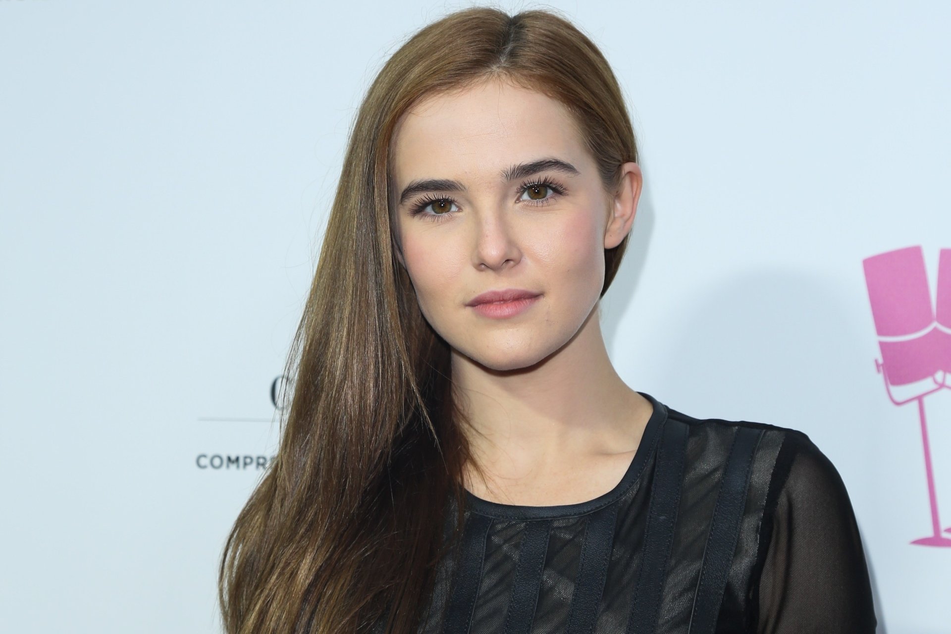 Portrait of an American brunette actress and celebrity in a soft-lit head-and-shoulders shot against a pale backdrop — 2K Quad HD PC desktop wallpaper.