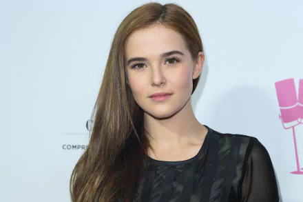 Portrait of an American brunette actress and celebrity in a soft-lit head-and-shoulders shot against a pale backdrop — 2K Quad HD PC desktop wallpaper.