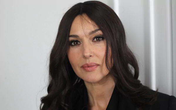 Close-up portrait of a woman with long black hair and brown eyes, subtle makeup and a calm expression against a neutral background, 2K Quad HD PC desktop wallpaper.