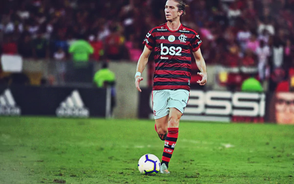 HD PC wallpaper: Clube de Regatas do Flamengo player in red-and-black kit on the pitch, poised over the ball with a stadium crowd in the background.