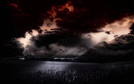 Dramatic black and white landscape featuring a vast field under ominous, dark clouds, creating a striking nature-themed HD desktop wallpaper.