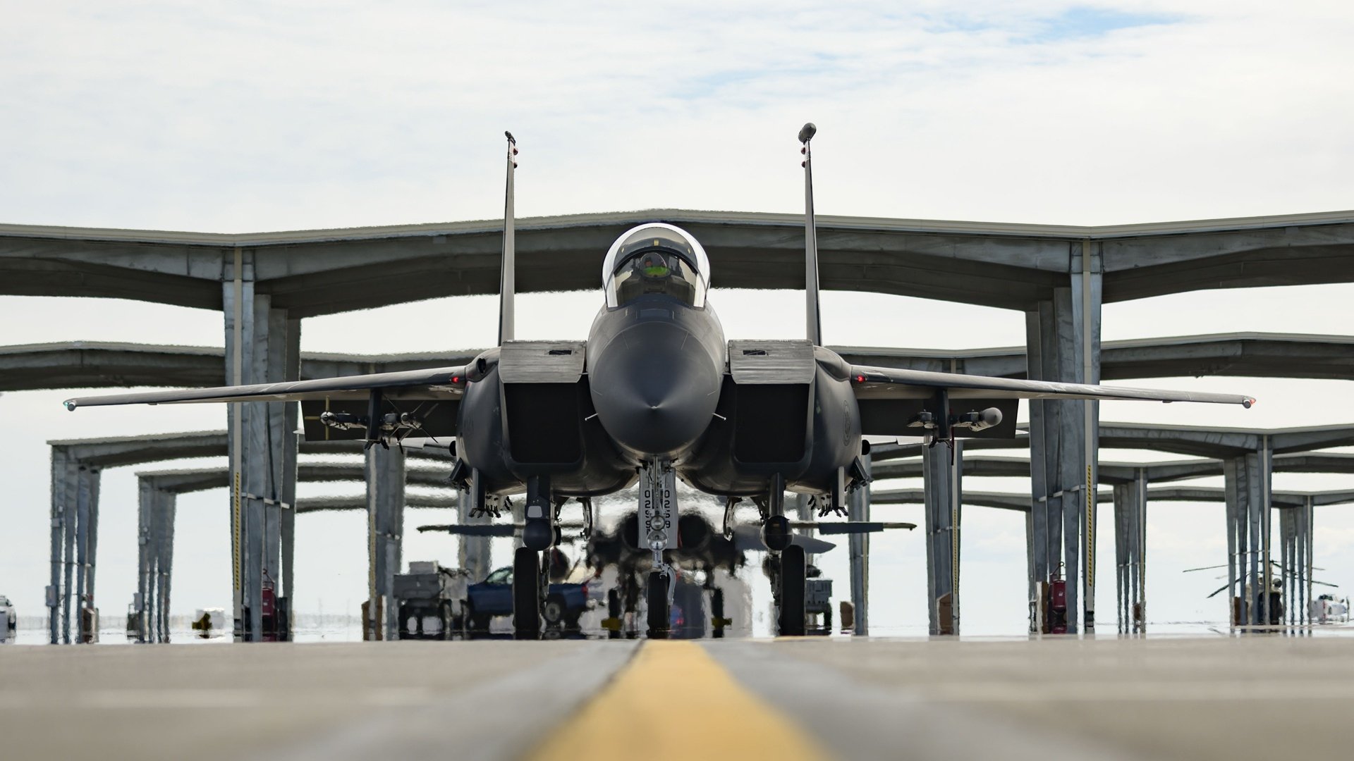 Front view of a McDonnell Douglas F-15 Eagle jet fighter parked under a military hangar, captured in high definition as an HD PC desktop wallpaper background.