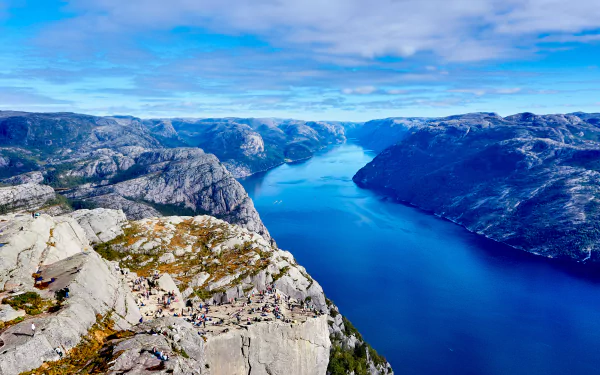 4K Ultra HD desktop wallpaper showing a vast river winding through rugged mountains under a bright blue sky, capturing the beauty of untouched nature.