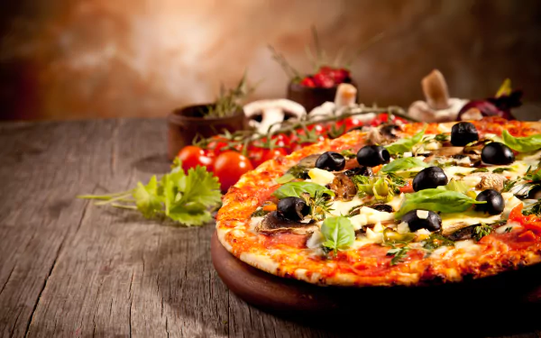HD wallpaper of a vibrant pizza still life, featuring a freshly made pizza with olives, herbs, and vegetables on a rustic wooden table.
