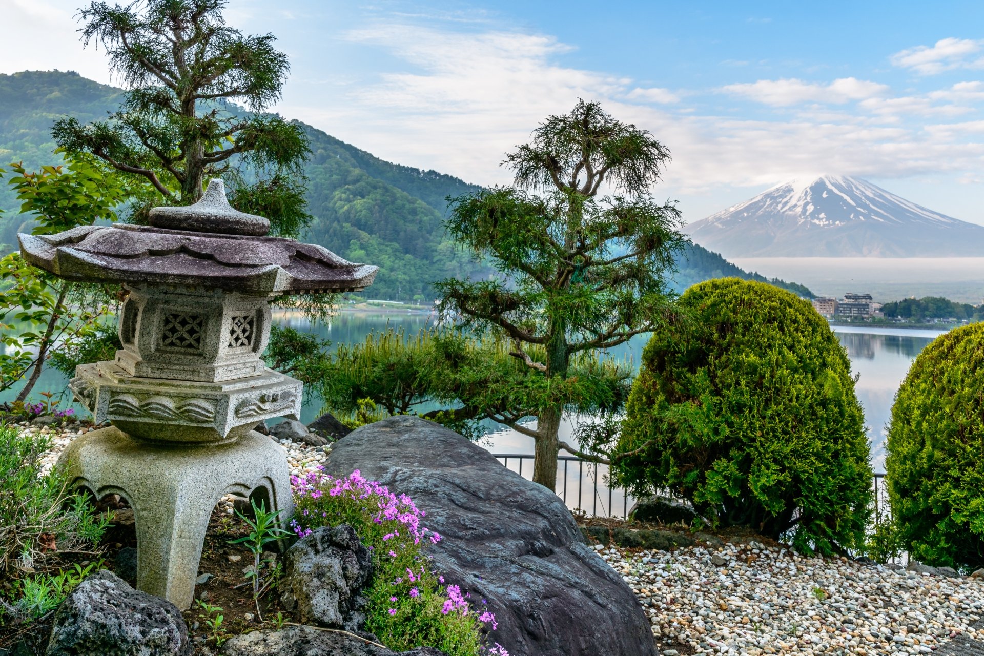 5K Ultra HD PC desktop wallpaper of Mount Fuji in Japan: tranquil mountain and lakeside garden with a stone lantern, evergreens, rocks, and blooming flowers.