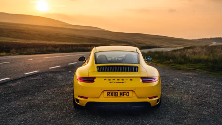 Rear view of a yellow Porsche 911 Carrera T on a winding road at sunset, 4K Ultra HD PC desktop wallpaper.
