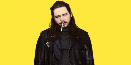 HD desktop wallpaper of Post Malone in a black leather jacket against a yellow background.