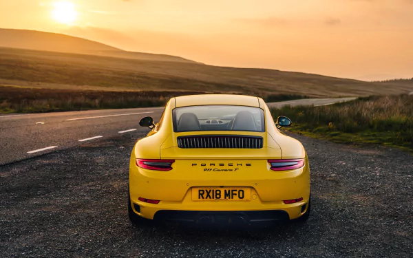 Rear view of a yellow Porsche 911 Carrera T on a winding road at sunset, 4K Ultra HD PC desktop wallpaper.