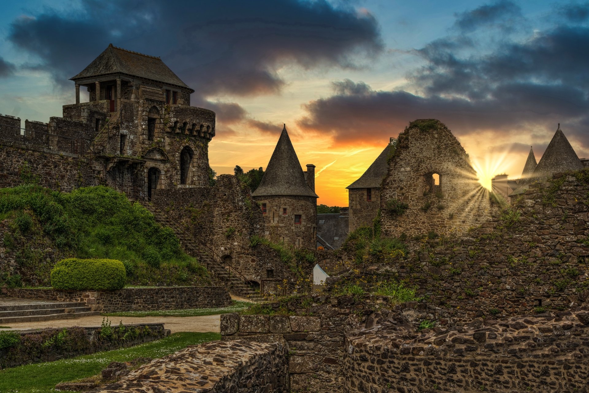 4K Ultra HD desktop wallpaper of an ancient man-made fortress with stone towers and castle walls under a dramatic sunset sky.