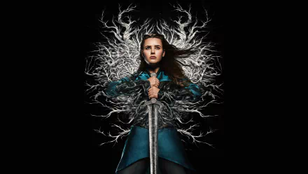 HD wallpaper of Katherine Langford from Cursed holding a sword with a mystical backdrop.