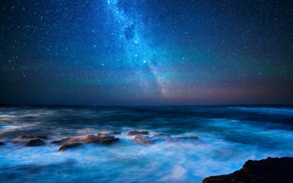 HD desktop wallpaper of Australia's rocky coastline under a vibrant Milky Way galaxy, blending sci-fi ambiance with natural night sky beauty.