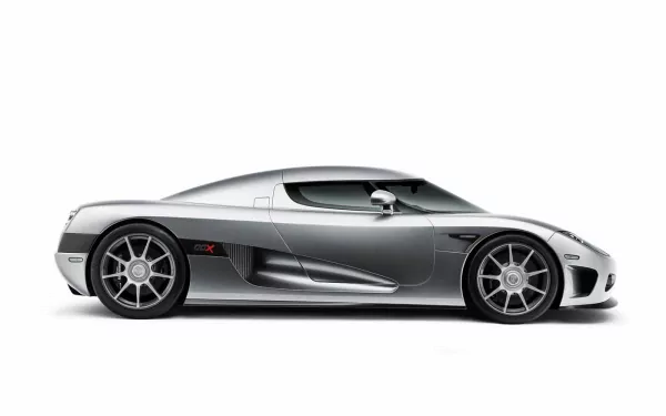 A sleek silver Koenigsegg CCX vehicle displayed in profile, showcasing its aerodynamic design and high-performance wheels, set against a clean background, designed for high-definition screens.