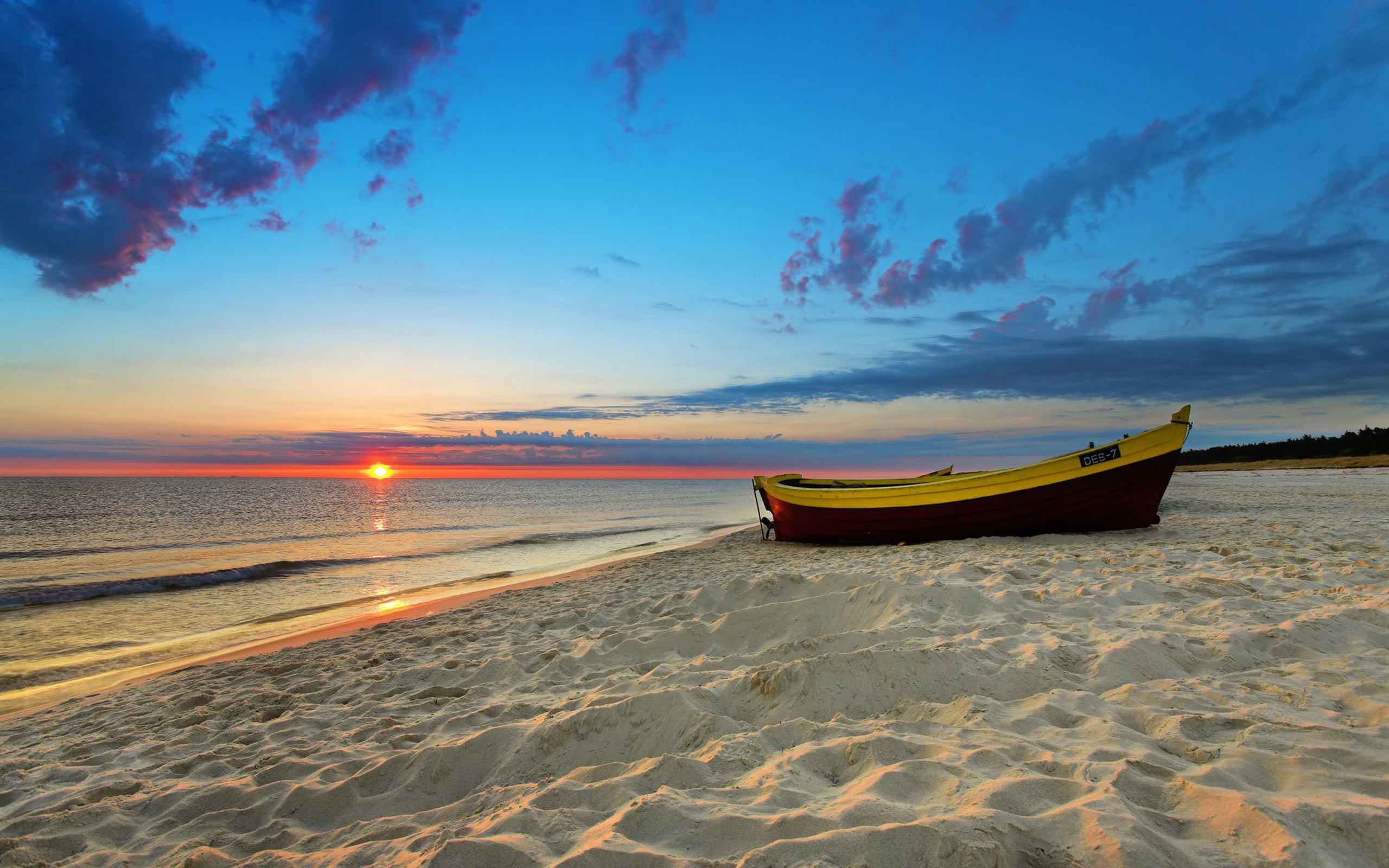 Sunset Beach with a boat resting on calm ocean waters.
