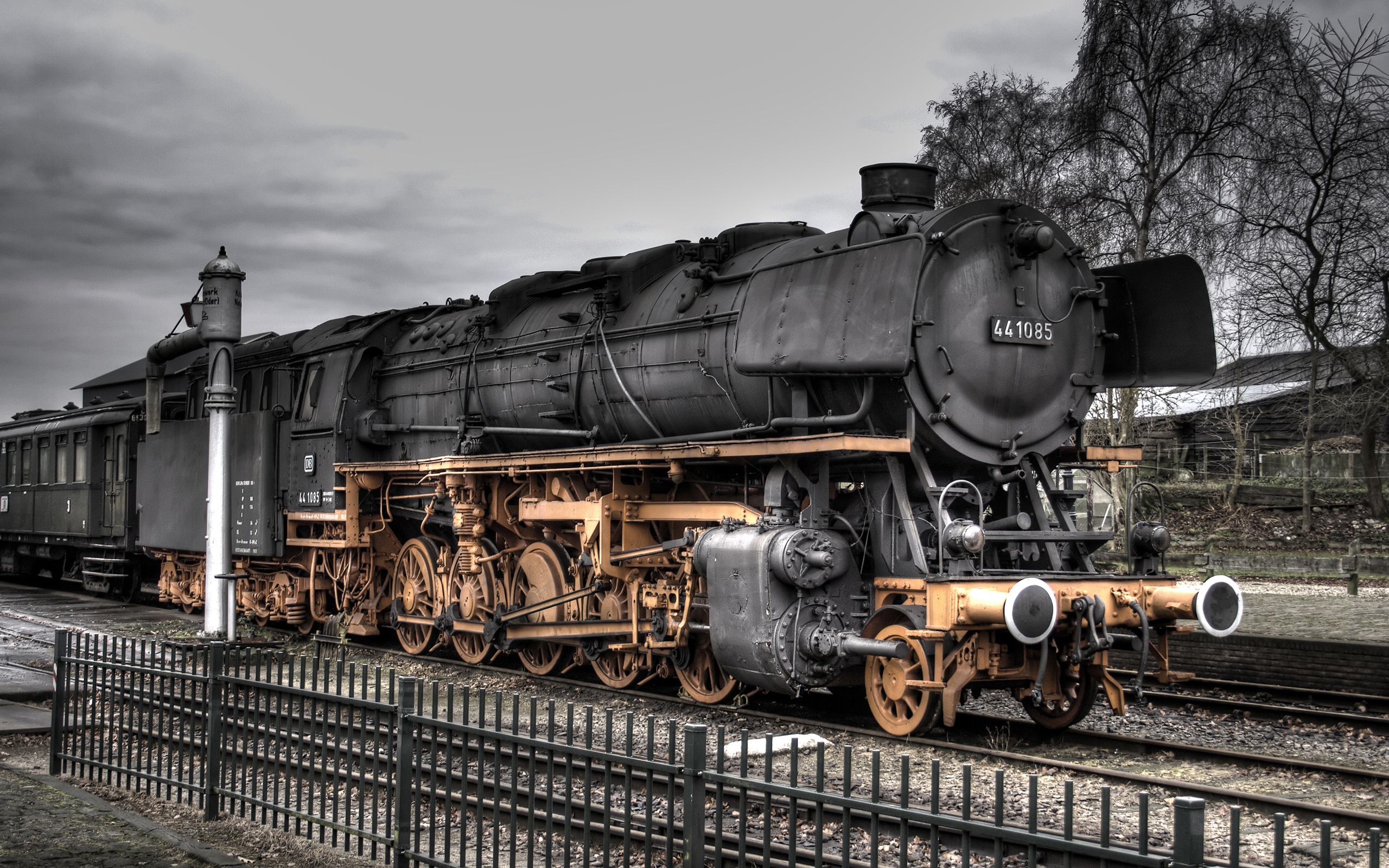 Beautifully restored steam train locomotive emerging from a tunnel, against a vibrant HDR background.