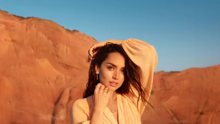 High-resolution 8K wallpaper of Cuban actress Ana de Armas with green eyes and brunette hair, posing outdoors against a desert landscape background.