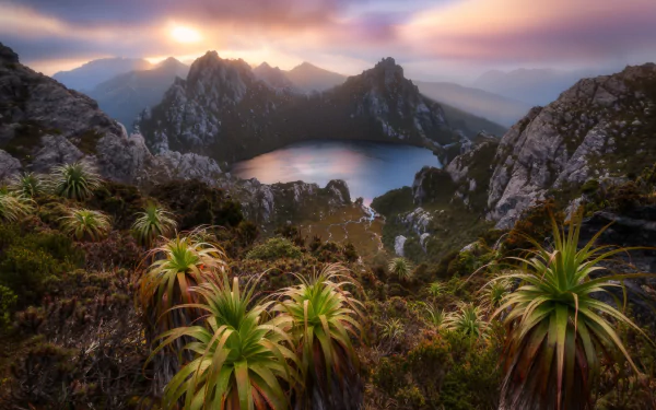 Sunrise over Lake Oberon in the Western Arthurs, Tasmania, Australia, showcasing rugged mountains, lush vegetation, and a serene lake in this stunning HD landscape wallpaper.